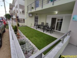 a backyard with a lawn in front of a house at Ηλιοκαλλη - ILIOKALLI in Néa Péramos