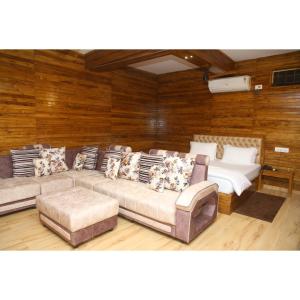 a living room with a couch and two beds at Woods Residency in Jaypur