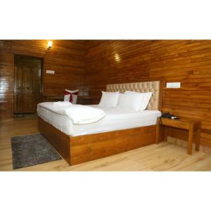 una camera da letto con un grande letto e pareti in legno di Woods Residency a Jaypur