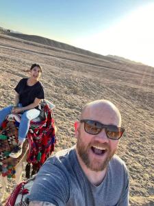un hombre y una mujer montados en un camello en Apadi camp, en Coraya Bay