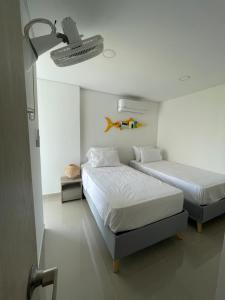 a bedroom with two beds and a light on the ceiling at Infinity Blue - Playa Dormida in Santa Marta