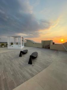 a view of a rooftop with two black benches at Infinity Blue - Playa Dormida in Santa Marta
