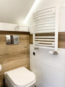 レバにあるNawrotówkaの白いトイレと木製の壁が備わるバスルーム
