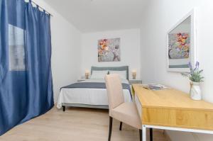 ein Schlafzimmer mit einem Bett und einem Tisch mit einem Stuhl in der Unterkunft Blue moon Split Apartment in Split