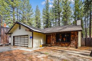 a house with a garage in the woods at Pet Friendly - Close To Heavenly, Steps To The River in South Lake Tahoe