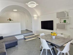 a living room with a table and white chairs at Annarosa Home in Vico Equense