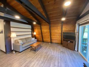 uma sala de estar com um sofá e uma televisão em A Cozy Cabin Steps From Mountain Trails And Hiking em Mevers