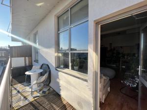 a balcony with a window and a table and chairs at Room with share bathroom in London