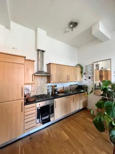 cocina grande con armarios de madera y fogones en Room with share bathroom, en Londres