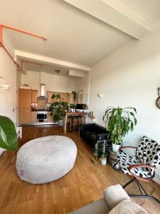 una sala de estar con reposapiés en el medio de una habitación en Room with share bathroom en Londres