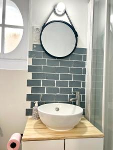 a bathroom with a sink and a mirror at La persienne Bleue - Coeur historique de Mortagne au Perche in Mortagne-au-Perche
