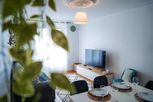 een woonkamer met tafels en stoelen en een televisie bij Le Straw' Berry • Fibre • Calme in Châteauroux