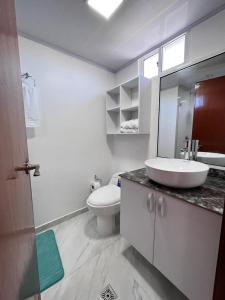 a white bathroom with a sink and a toilet at Liliana Prado Edificio Bailey Boat Apt 303 in San Andrés