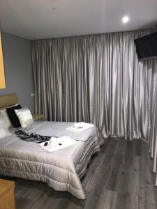 a bedroom with two beds and a window with curtains at Restaurante Residencial Pizzaria S. Estevão in Aguiar da Beira