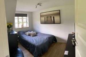 1 dormitorio con cama y espejo en la pared en Naturskøn landidyl på Ibækgaarden - I egen bolig, en Vejle