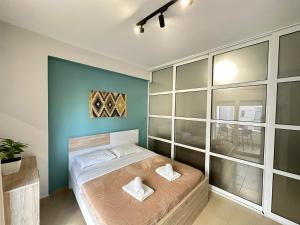 een slaapkamer met een bed en een blauwe muur bij TreA Accomodations - On Private Beach with sunbed & umbrella in Vlorë