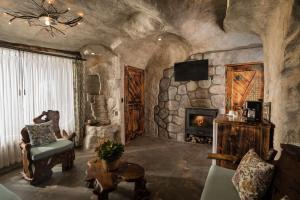 sala de estar con chimenea y pared de piedra en Estancia San Juan en Cuenca