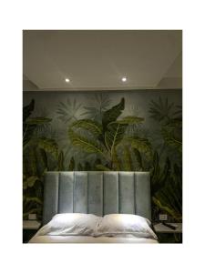 ein Schlafzimmer mit einem Wandbild aus Pflanzen in der Unterkunft B&B Buona Stella in Pimonte