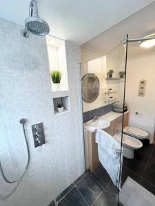 a bathroom with a shower and a sink and a toilet at Beautiful 2 bedroom garden flat w/ free parking in Surbiton