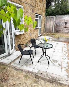 a patio with a table and two chairs on a patio at Beautiful 2 bedroom garden flat w/ free parking in Surbiton