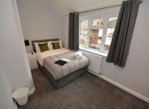 um quarto com uma cama com um gato sentado nela em Walton Suites em Watford