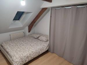 een kleine slaapkamer met een bed en een raam bij Duplex, Le Citadin in Cherbourg en Cotentin