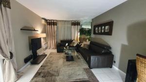 ein Wohnzimmer mit Sofa und Fernseher in der Unterkunft Mélodie Garage Gratuit in Cannes