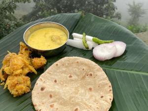 a plate of food on a banana leaf with a dip at SERENITY CAMPS, MUSSOURIE in Mussoorie