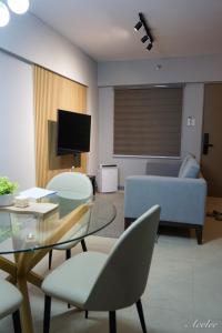 a living room with a couch and a table and chairs at Alea Residences in Manila