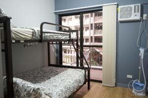 a room with two bunk beds and a window at Alea Residences in Manila