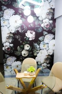 a table and chairs in front of a floral wall at Alea Residences in Manila