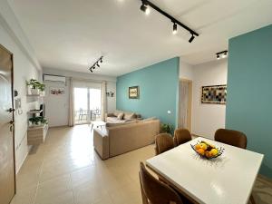 een woonkamer met een tafel en een bank bij TreA Accomodations - On Private Beach with sunbed & umbrella in Vlorë