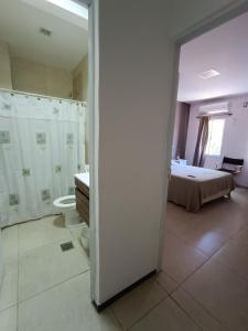 een slaapkamer met een bed en een badkamer met een toilet bij Apart Checatu Irupe in Corrientes