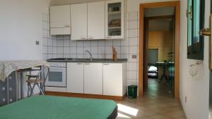 eine Küche mit weißen Schränken und einer Arbeitsplatte in der Unterkunft Casa Vacanze Mari Pintau in Geremèas