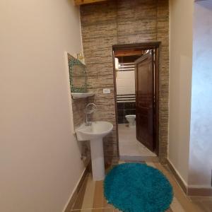 een badkamer met een wastafel, een toilet en een spiegel bij Boondok's house in Dahab