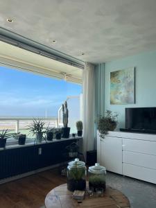 a living room with a large window with a view of the ocean at Apartment Fleurette in Zandvoort