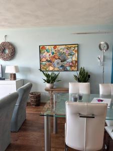 Apartment Fleurette في زاندفورت: غرفة طعام مع طاولة وكراسي زجاجية