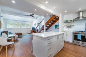 a kitchen with white cabinets and a dining room at The Surf Hale - Sleeps 4 - Elevated Surf Aesthetic in Kahuku