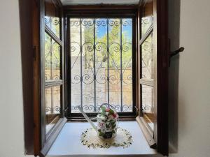 a window with a vase of flowers on a table at Traditional house in Koskinou in Koskinou