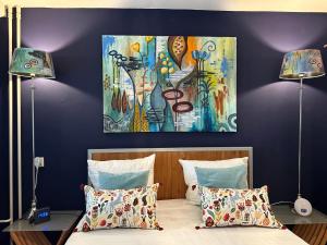 a bedroom with a painting on the wall at Apartment Fleurette in Zandvoort