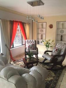 sala de estar con sofás, sillas y ventana en CASA ACOGEDORA ACORDE A TU ESTILO, en Palmira
