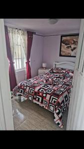 a bedroom with a bed with a red and white blanket at CASA ACOGEDORA ACORDE A TU ESTILO in Palmira