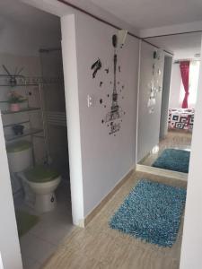 a bathroom with a toilet and two blue rugs at CASA ACOGEDORA ACORDE A TU ESTILO in Palmira