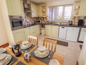a kitchen with a wooden table with chairs and a dining room at Nursery Cottage in Louth