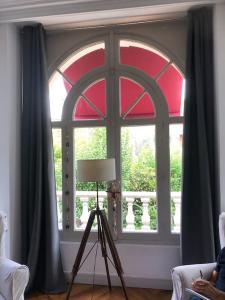 una camera con una grande finestra con un treppiede di fronte di CASTEL MT Villa spacieuse Luchon vue montagnes Pyrénées a Luchon