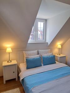 1 dormitorio con 1 cama grande con almohadas azules en APARTAMENTY TUŹNIKOWIE en Kazimierz Dolny