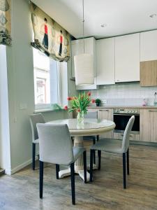 a kitchen with a table and chairs in a kitchen at Castle Apartaments host Kaunas with free parking in Kaunas