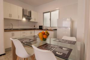 a kitchen with a glass table and white cabinets at Tendal Hosting - Cabrera Guerra in Santa Cruz de la Palma