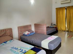 Habitación con 2 camas y 2 sillas. en MELATI INN en Kajang