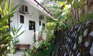 un camino de jardín que conduce a una casa blanca en MELATI INN en Kajang
